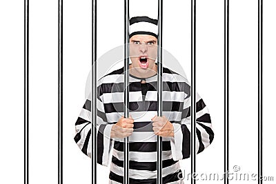 Angry prisoner standing behind bars