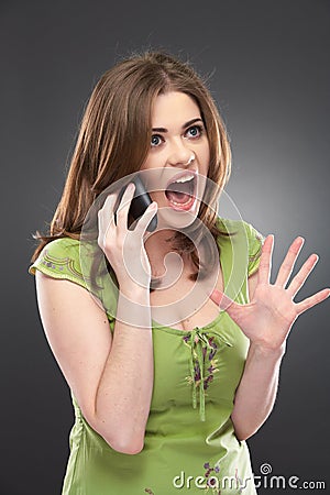 Angry woman shouts in phone isolated on gray