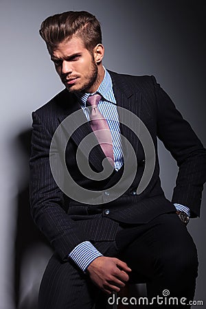 Angry young business man in classic suit and tie sitting