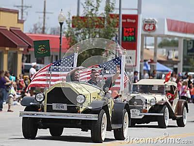 Antique car with American Flags in parade in small town America