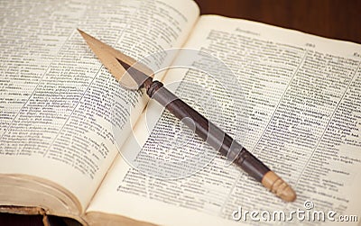 Antique dictionary with wooden knife on it