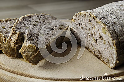 Appealing bread and bread slices on wood cutting board