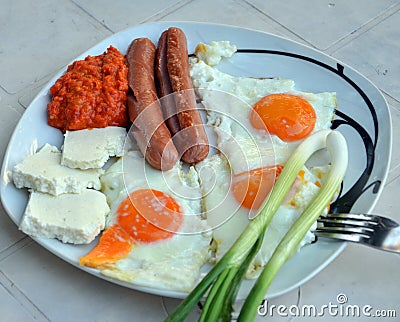 Appetizing breakfast with fried eggs and fried sausages