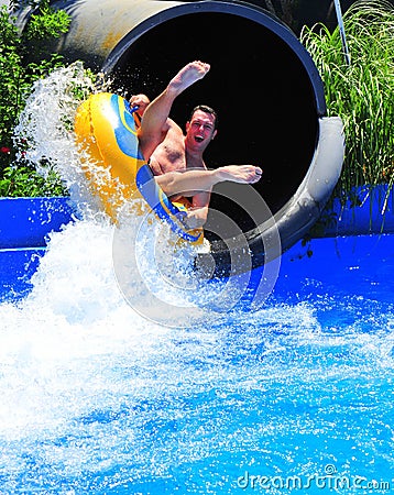 Aqua park fun - man enjoying a water tube ride