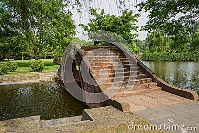 Arched stone bridge over water in sunny spring