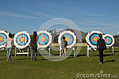Archer collecting arrows from the targets in the field