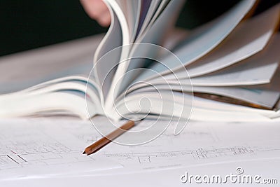 Architectural plan with open book and pencil