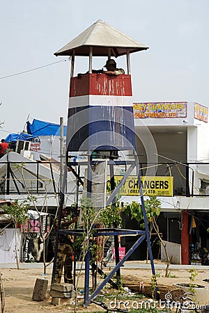 Armed policeman in a tower police post. India.