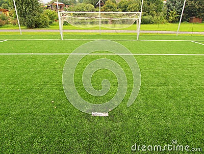 Artificial grass field on football playground. Detail of a cross of lines in a soccer field. Plastic grass and ground rubber