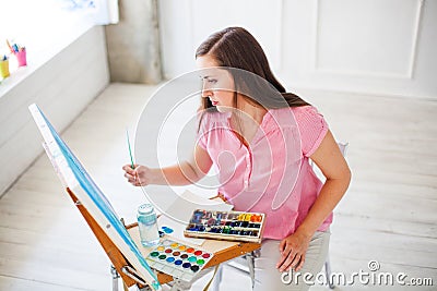 Artist painting picture on canvas whith watercolours