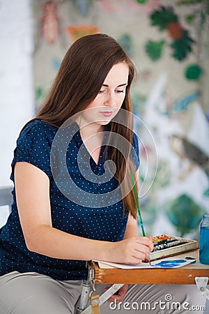 Artist painting picture on canvas whith watercolours