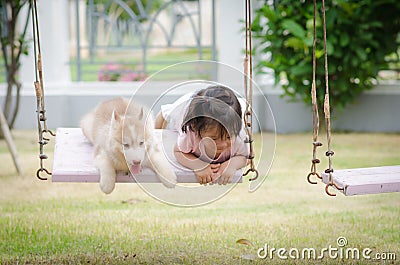 Asian baby baby on swing with puppy