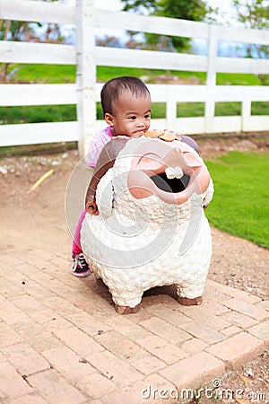 Asian baby girl ride sheep statue