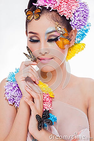 Asian Beautiful Girl With colorful make up with fresh Flowers and Butterfly