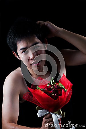 Asian boy with red bouquet in dark background