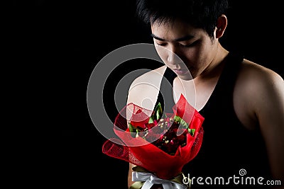 Asian boy with red bouquet in dark background