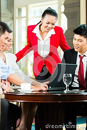 http://thumbs.dreamstime.com/x/asian-business-people-meeting-hotel-lobby-four-chinese-men-women-having-looking-documents-laptop-drinking-34447366.jpg