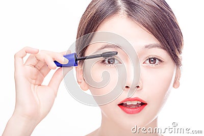 Asian female applying mascara