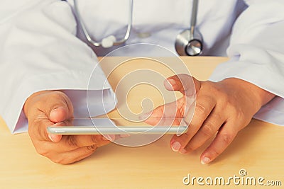 Asian female doctor diagnoses by using tablet.