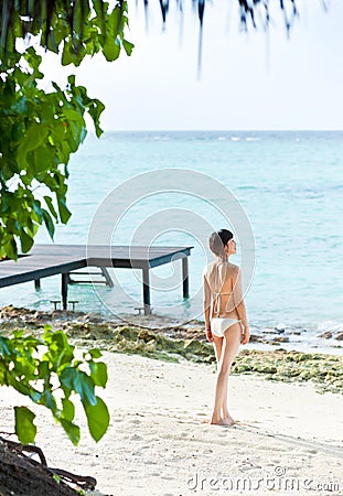 Asian girl in bikini standing on beach