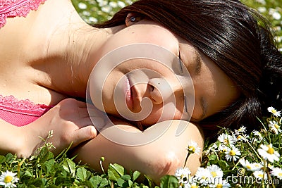 Asian girl sleeping in park surrounded by flowers