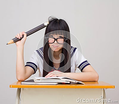 Asian girl student in school uniform studying with an oversize p