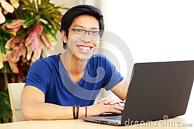 Asian man sitting at the table with laptop