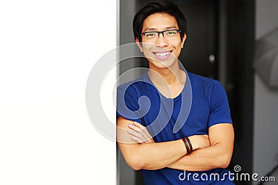 Asian man standing with arms folded