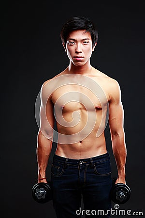 Asian man standing with dumbbells