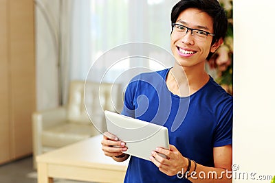 Asian man standing with tablet computer