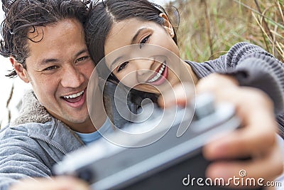 http://thumbs.dreamstime.com/x/asian-man-woman-couple-taking-selfie-photograph-young-chinese-men-boy-girl-sitting-sand-dunes-beach-retro-style-36791354.jpg