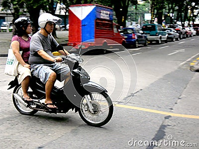 Asian man and woman riding a motorcycle