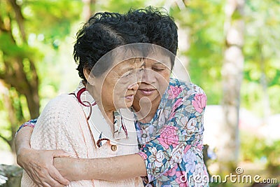 Asian mature woman hugs and consoling her crying old mother