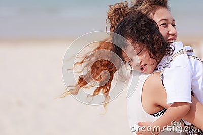 Asian mom and son playing on beach