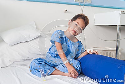 Asian patient boy with saline intravenous (iv) on hospital bed.