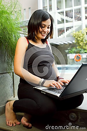 Asian pregnant woman happy working with laptop