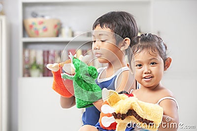 Asian sibling playing hand puppet