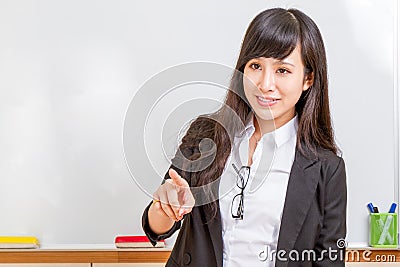 Asian teacher in front of whiteboard pointing