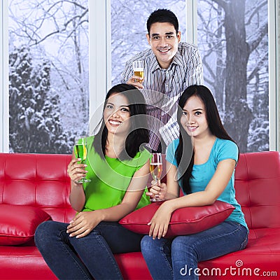 Asian teenager drinking champagne on sofa