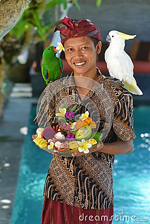 Asian waiter with a tray of tropical fruits