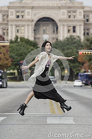 Asian Woman in lifestyle locations crossing the street street in front of Capital building in Austin, Texas