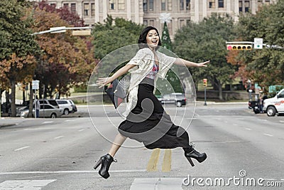 Asian Woman in lifestyle locations crossing the street street in front of Capital building in Austin, Texas
