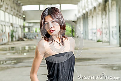 Asian woman in remains of old building