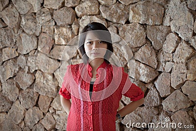 Asian woman standing in font of rock wall