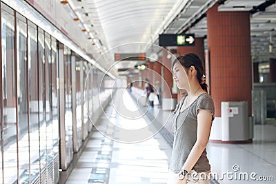 Asian woman waiting for train