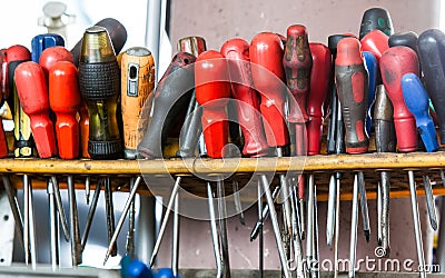 Assortment of tools hanging on wall. Screwdrivers in mechanic garage car service