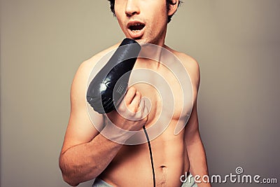 Athletic young man with a hair dryer