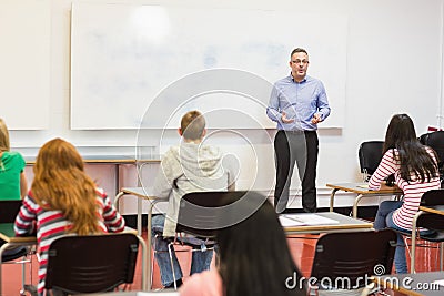 Attentive students with teacher in the classroom
