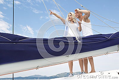 Attractive couple standing on sailing boat - sailing trip.