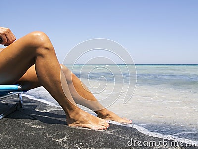 Attractive female legs relaxing on a beautiful beach